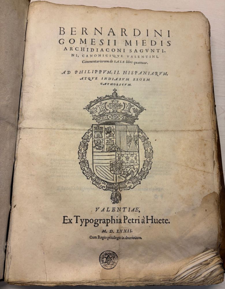 Title page of the sixteenth-century book with the title Commentariorum de sale libri quattuor. The imprint informs us that the book was printed by Petrus à Huete in Valencia in 1572. The title page also features woodcut engraving of a coat of arms