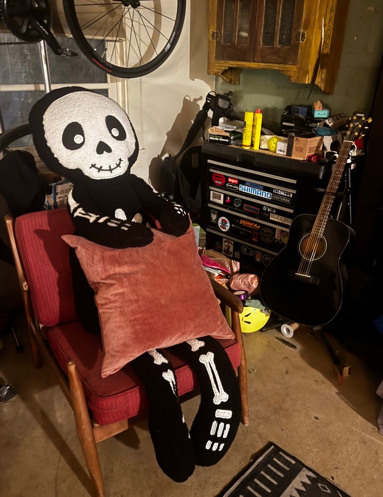 giant stuffed skeleton sitting in a chair