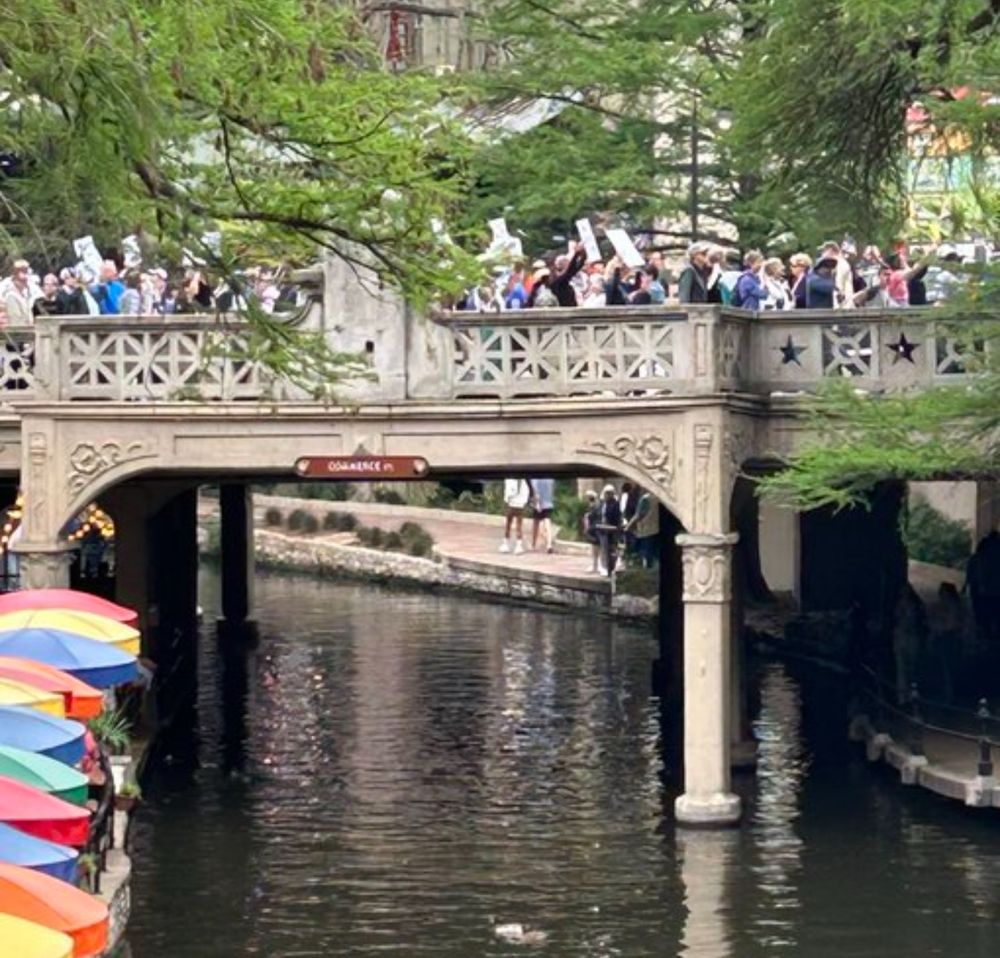 people marching over the riverwalk