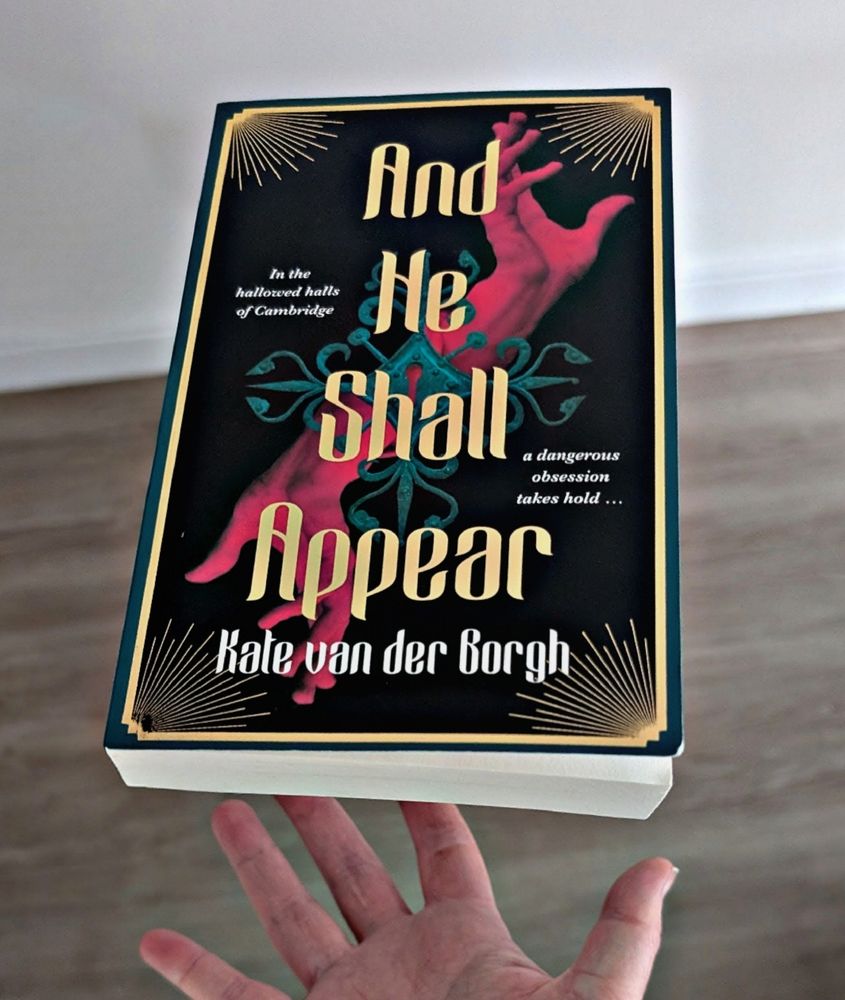 And he shall appear by Kate Van Der Borgh hovering above a hand. Wooden floor below.