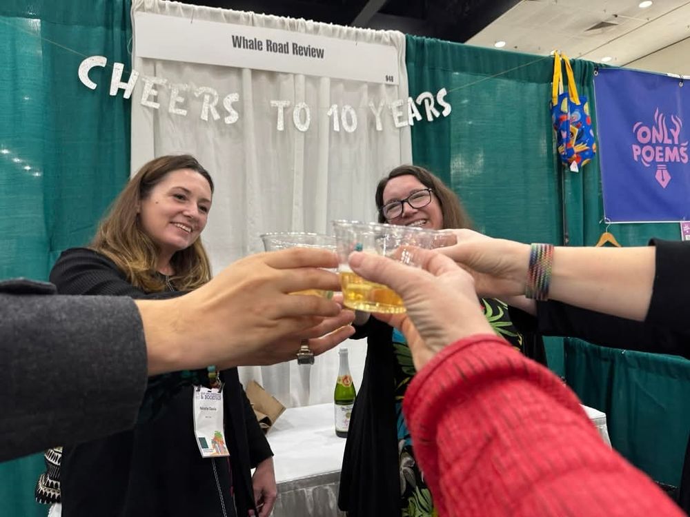 Happy writers toast with little cups at the Whale Road review