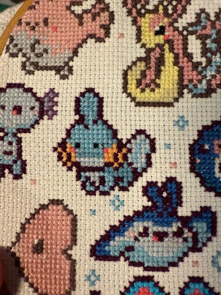 My Cross stitch showing a complete Mudkip. It’s almost fully done except for some last finishing touches!! 