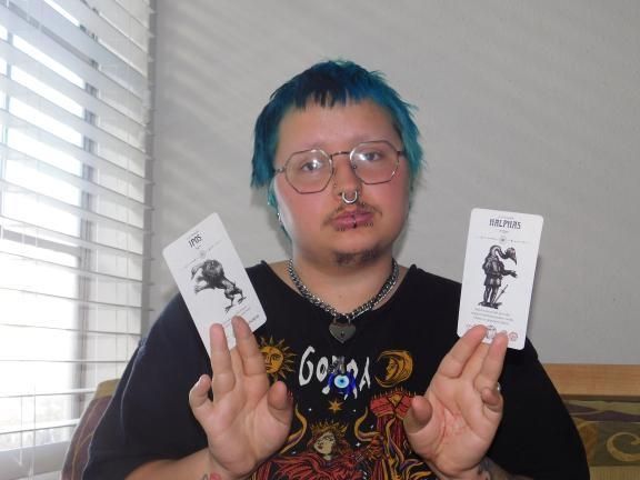 Kit holding up two cards from the Occult Tarot deck. 