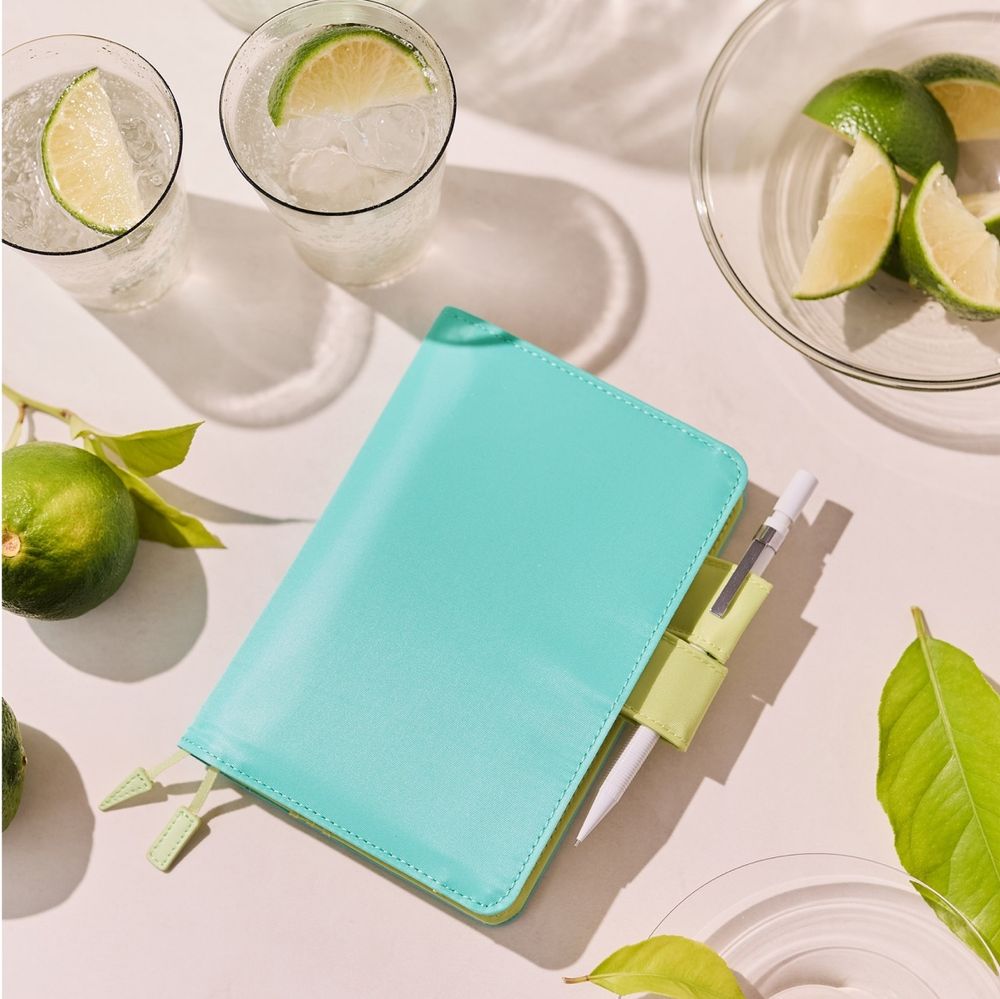 Hobonichi 2026 A6 cover in "Aqua Green." Closed cover view showing a light blue cover with lime green pen loops. Not pictured: me, crying furiously.