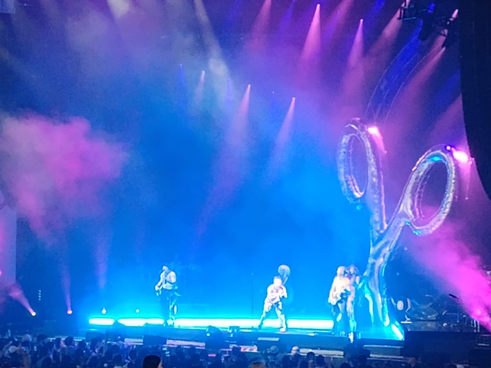 Scissor Sisters performing on stage with a large inflatable pair of scissors behind them.