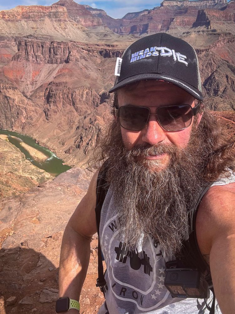 Selfie of an aging hippy with a beard and hat in the Grand Canyon, with the Colorado River visible.