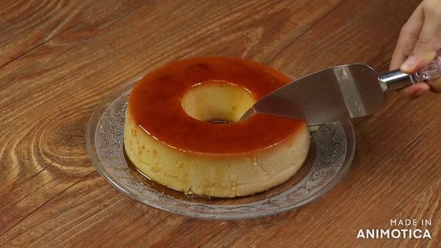 a slice of flan is being taken out of a cake on a glass plate