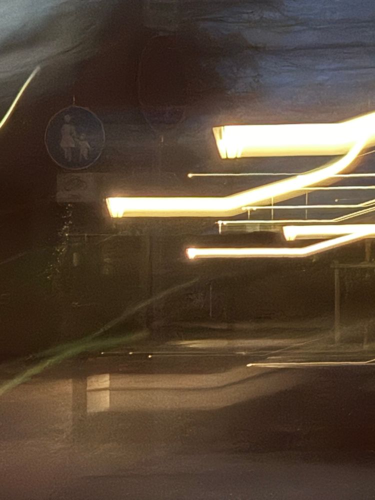 Durch verziehen der Kamera sind im oberen Teil des Fotos sieben breite und schmale Lichtlinien erzeugt worden, im unteren Bereich sind vier wesentlich schwächere Lichtlinien erkennbar.
Insgesamt existiert eine dunkle undeutliche Atmosphäre in warmen Tönen 