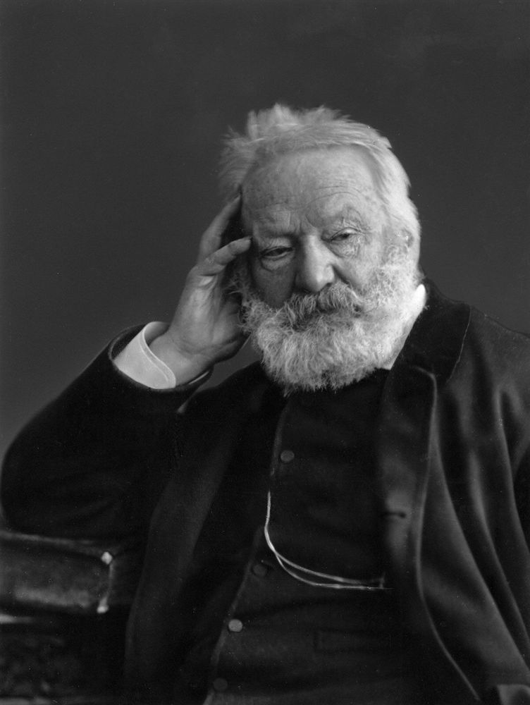 A black and white picture of an old, well-dressed Victor Hugo, holding his head with his hand.
