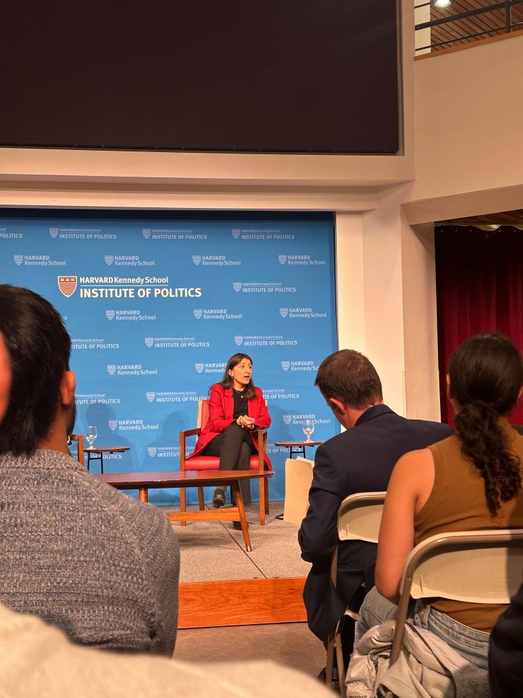 Lina Khan answering audience questions with Harvard Kennedy School Institute of Politics signage behind her 