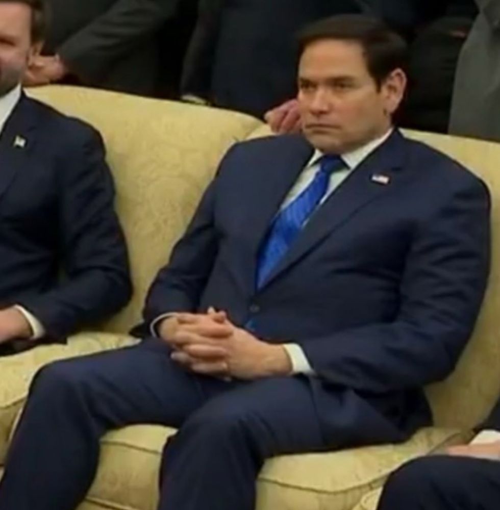 Marco Rubio sitting on a horrible yellowish couch next to a guy who fucks couches like that.