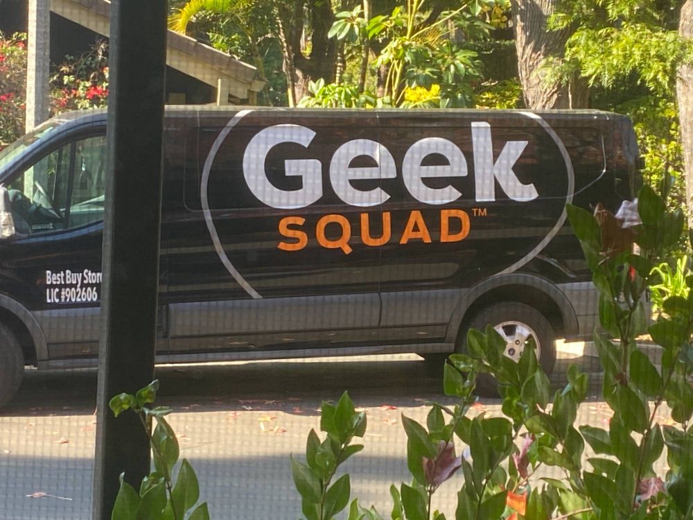A black van labeled "Geek Squad"