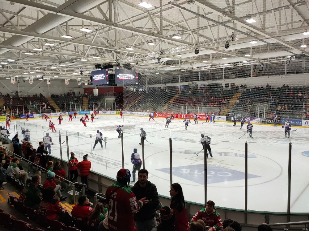 Two ice hockey teams warming up before a game.  All players are on the ice.