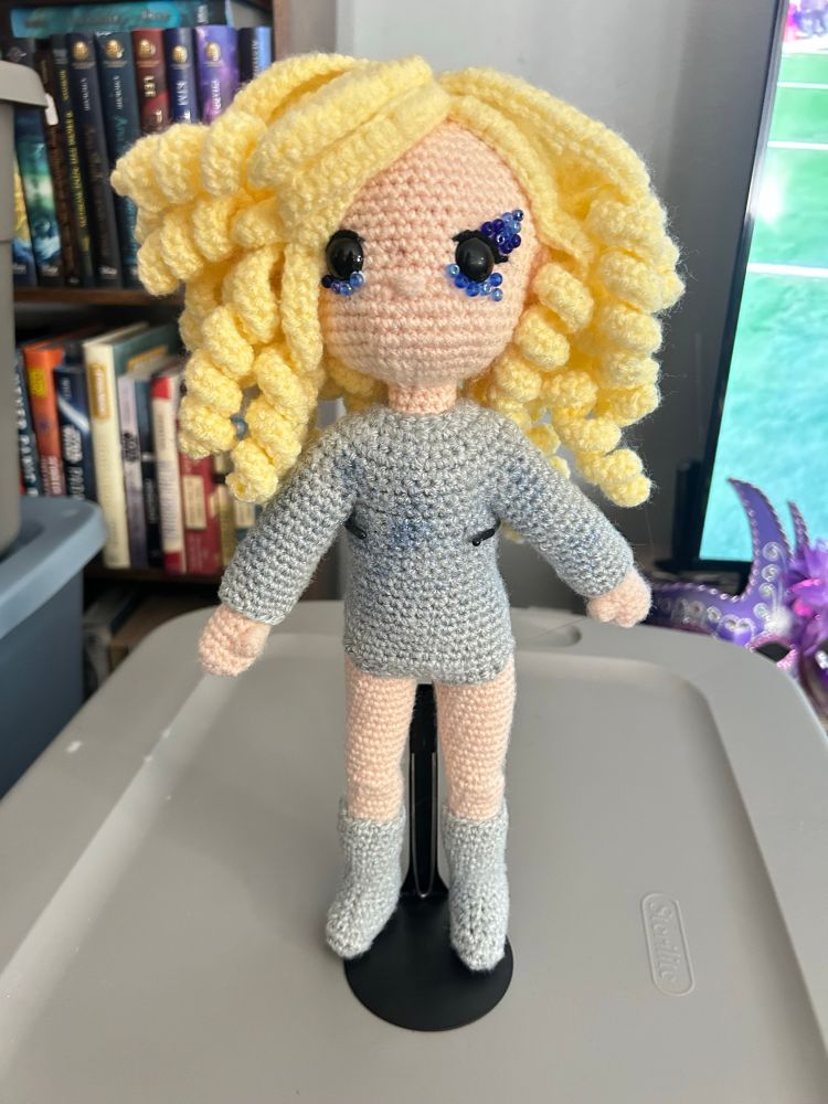Crocheted Lay Gaga with a silver body suit, silver boots,and lots of curly light blond hair 