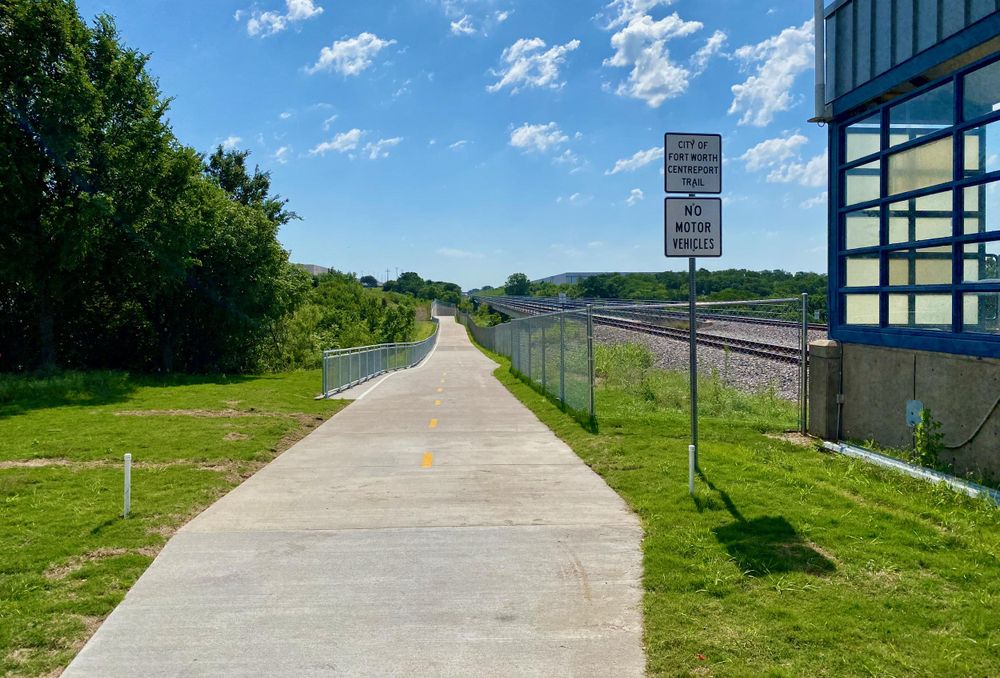 A photo of the newly built CentrePort Trail, connecting the CentrePort/DFW Airport ail station with the River Legacy East Trail. Concrete surface typical for the area.
