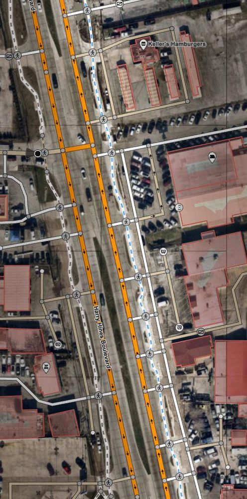 An aerial photo of part of Harry Hines with a map overlayed, showing just a silly number of driveways along the road, which chops the path up into tiny bits.