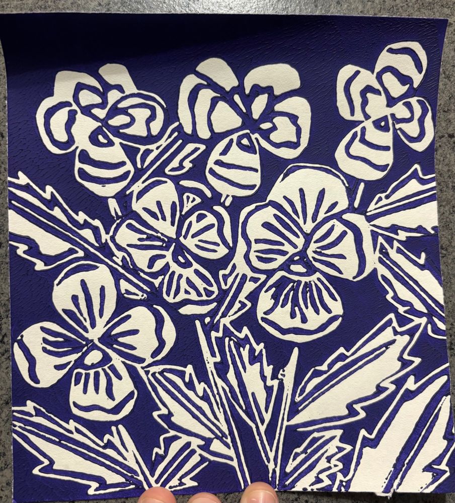 A linocut print of pansies in violet ink 