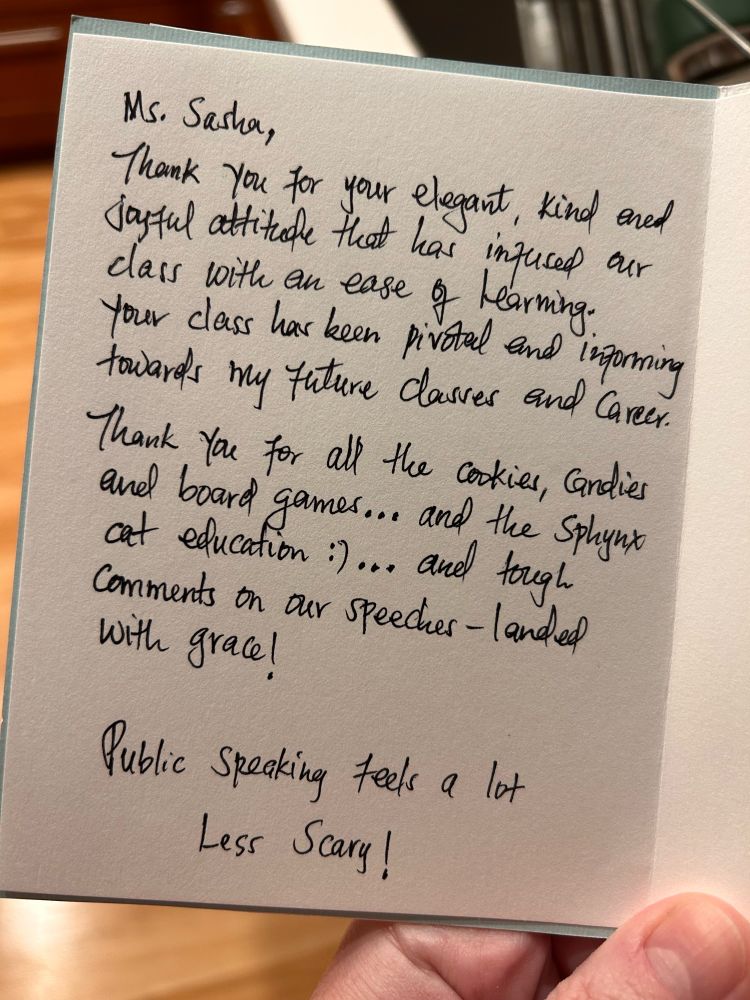 Note reads: Ms. Sasha, Thank you for your elegant, kind and joyful attitude that has infused our class with an ease of learning. Your class has been pivotal and informing towards my future classes and career. Thank you for all the cookies, candies and board games… And the sphynx cat education :)… And tough comments on our speeches – landed with grace! Public speaking feels a lot less scary!