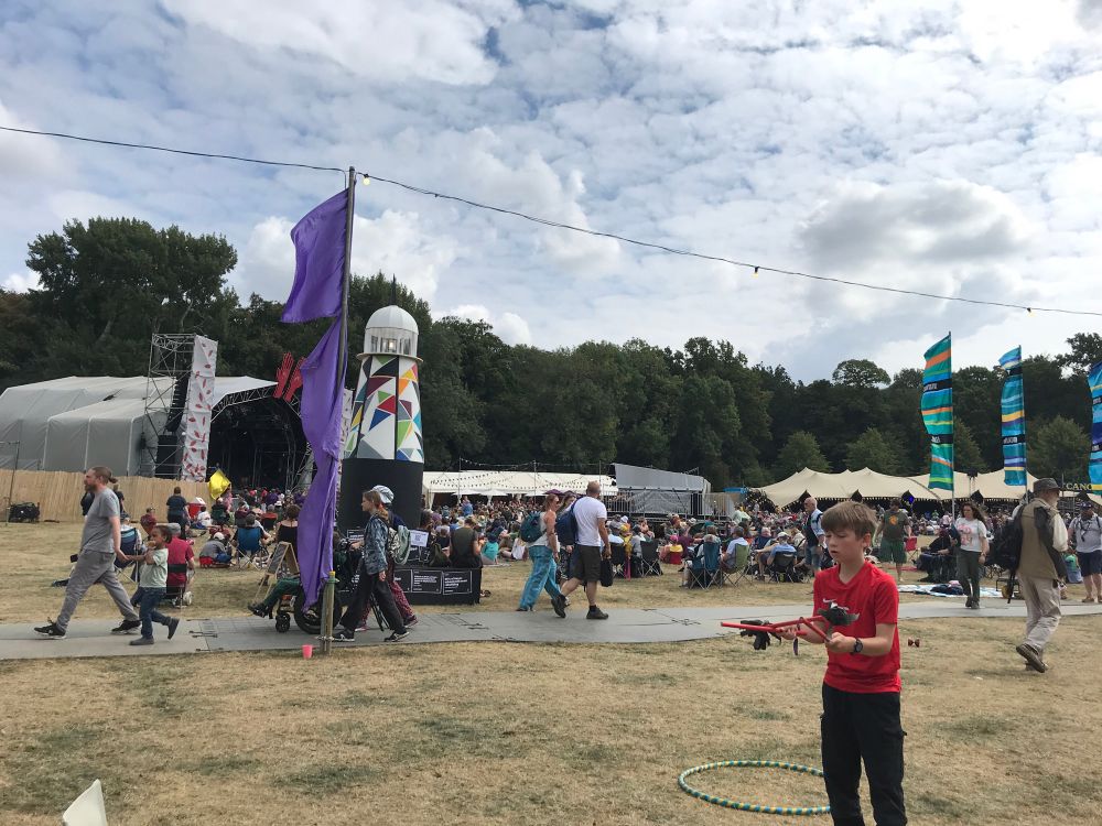 Photo of boy in foreground doing Diablo, with the Glade stage and lighthouse behind and crowds of people mooching about 