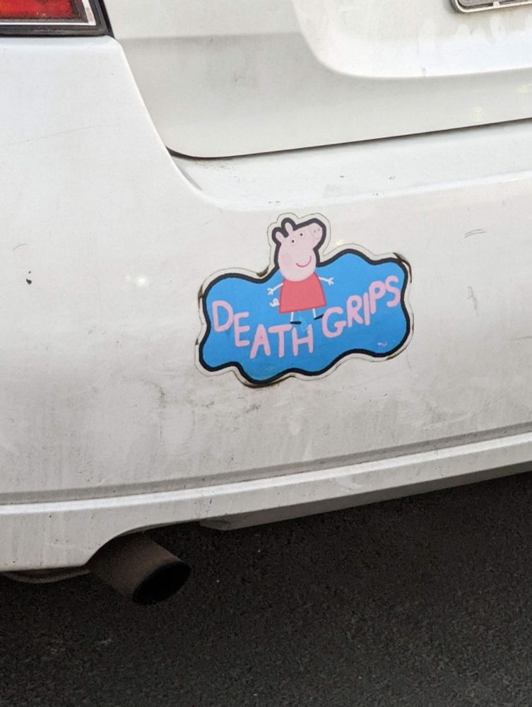 A bumper sticker that says "death grips" with Peppa pig above it