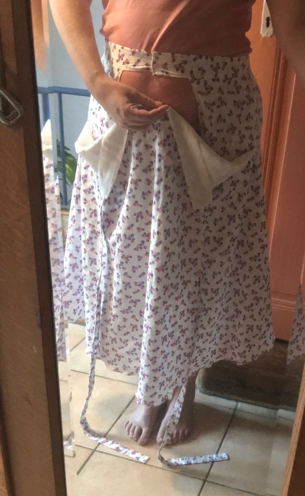 L’arrière s’attache d’abord devant. Les deux poches sont cousues sur cette partie. Je tiens l’avant, qui s’attache au dos avec les longues lanières dans le même tissu. Les côtés sont cousus ensemble jusqu’au bas de l’ouverture des poches. On voit la doublure en viscose blanche beaucoup plus douces que le voile coton dont l’imprimé est râpeux pour des détails blancs épais. #couture #jupe #garmentsewing #sewsky