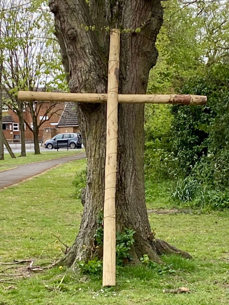 Wooden cross against a tree.