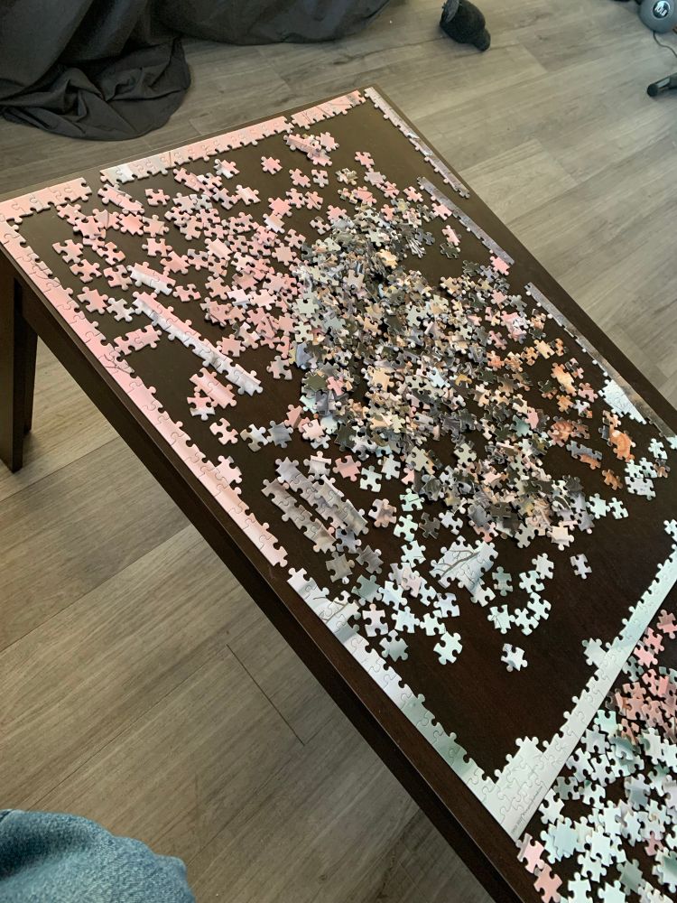 an unfinished puzzle on a coffee table, the borders nearly fully constructed.