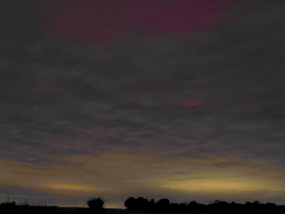 purple colour in the night sky indicating aurora borealis, but very cloudy