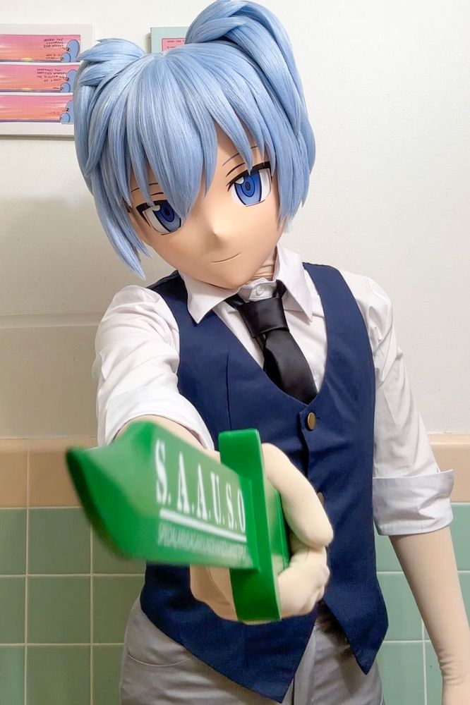 A photo of a kigurumi (anime mask) character. He's Nagisa Shiota from Assassination Classroom. He's brandishing a large green knife in his right hand, pointing it at the camera. 