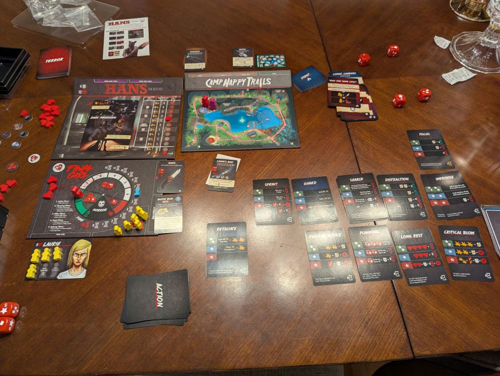 Endgame layout of Final Girl, with Hans at Camp Happy Trails getting defeated by Laurie. The most notable thing on the board is Laurie's white health token, showing she died but miraculously got back up with extra health.
