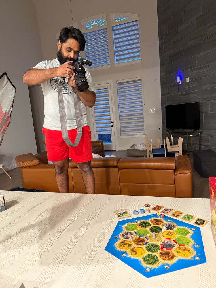 Photo of me taking a photo of the boardgame Catan with my professional photography equipment 