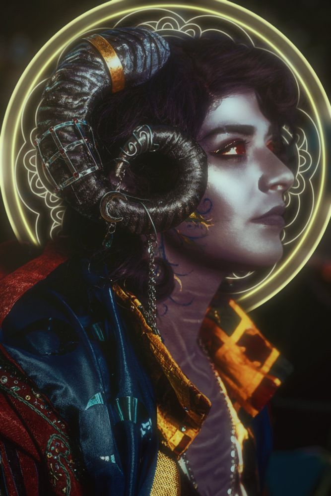 Portrait of a cosplayer cosplaying Molymauk from critical role. There’s a glow about them and a glowing halo behind them