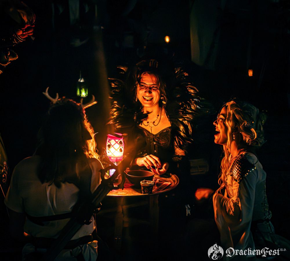 A coven of witches around a lantern 