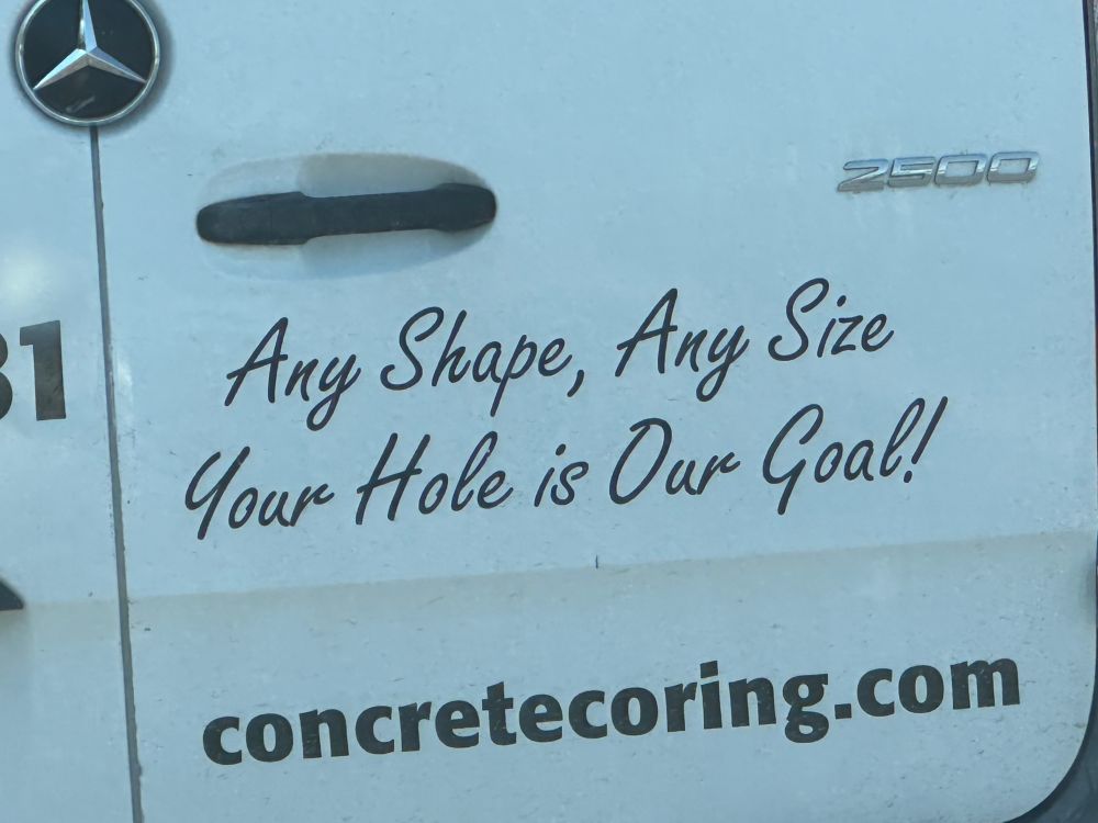 A picture of a back of a concrete coring van with the slogan: any shape, any size your hole is our goal!