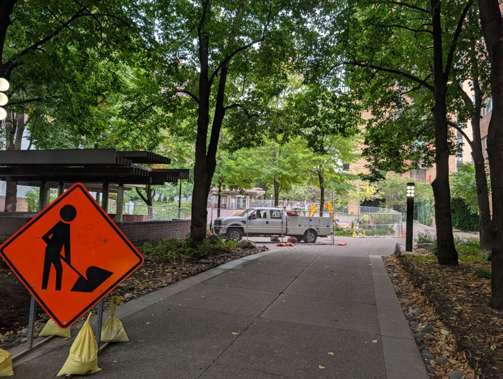 Picture of construction fencing and signs along with a work truck that now surround the site of the new playground.