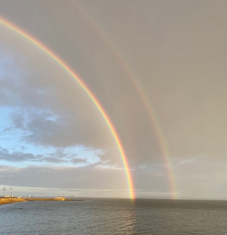 A double rainbow arching into the sea at Salthill, Galway
