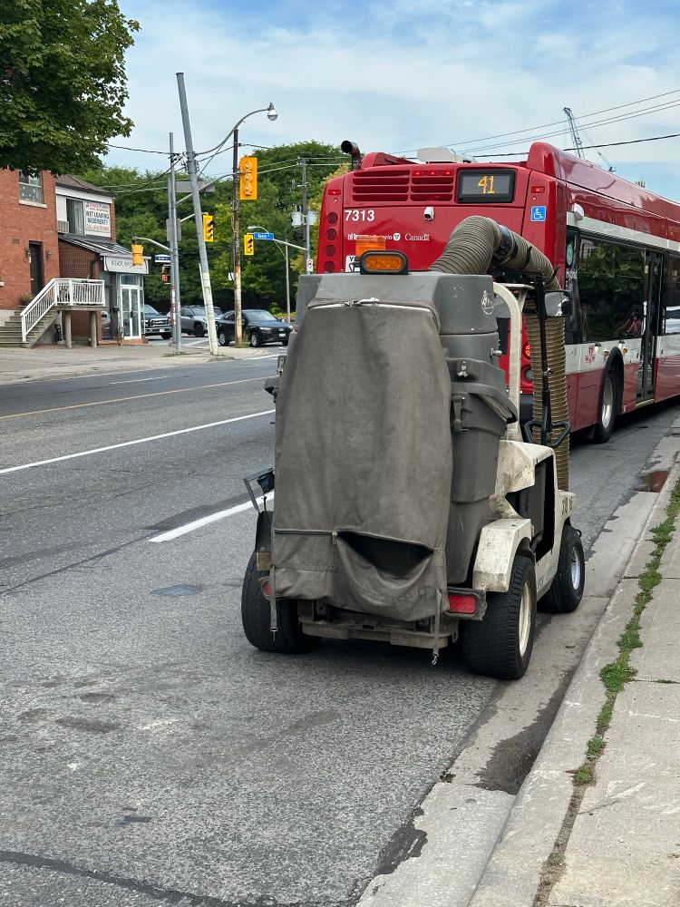 City of Toronto sidewalk and bike lane ride on vacuum cleaner parked with back zipper open. 