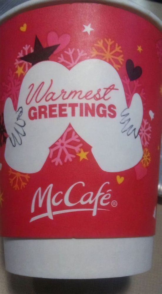 A McDonalds Christmas cup design that says McCafe Warmest Greetings on it 
