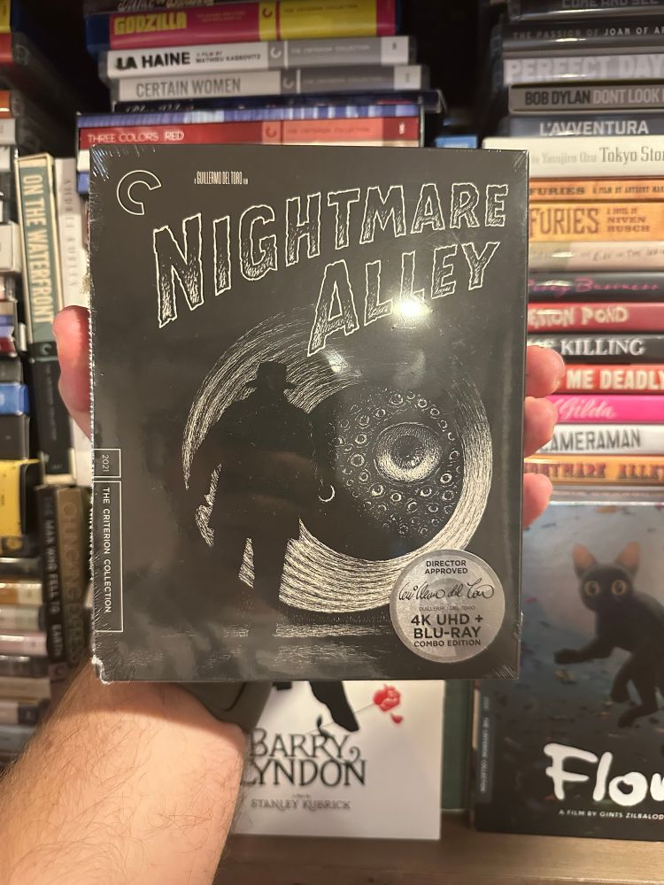 Guillermo Del Toro’s nightmare alley on 4K UHD from Criterion. The cover is a dark figure looking down a tunnel and flashing a light on what looks to be an eyeball creature. 