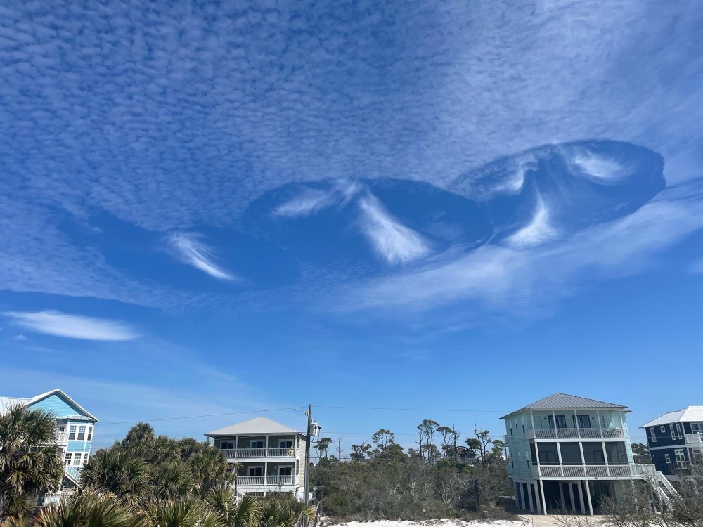 Fallstreak holes in a thin layer of clouds over Cape San Blas, Florida.