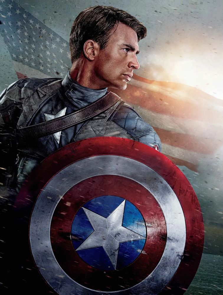 Captain America from the front, looking over his left shoulder.  He holds his red-white-and-blue shield in his left hand, facing the camera.  The American flag is in the semi-transparent background.