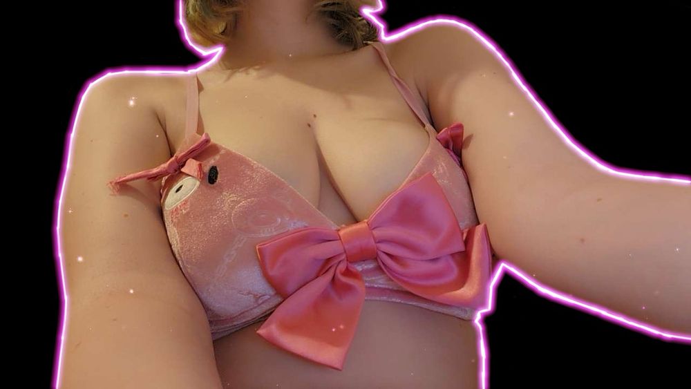 Vampiricc, sitting up straight. She is wearing moeflavor’s gloomy bear bikini top in pink. There is a neon pink outline around her silhouette.