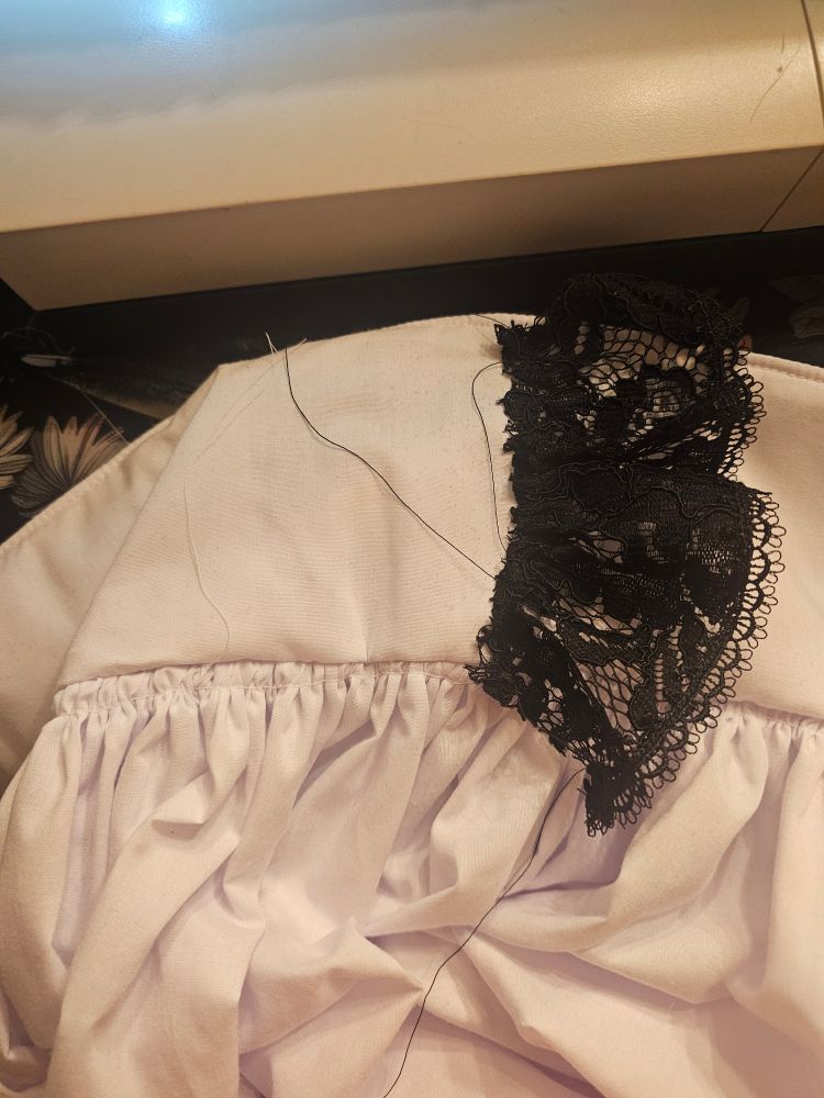 A piece of gathered lace on an apron waistband
