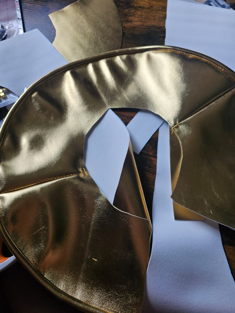 A gold pleather circle with matching piping around the edge
