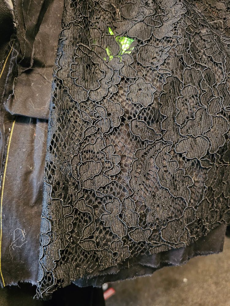 Black lace fabric laid on top of opaque black fabric
