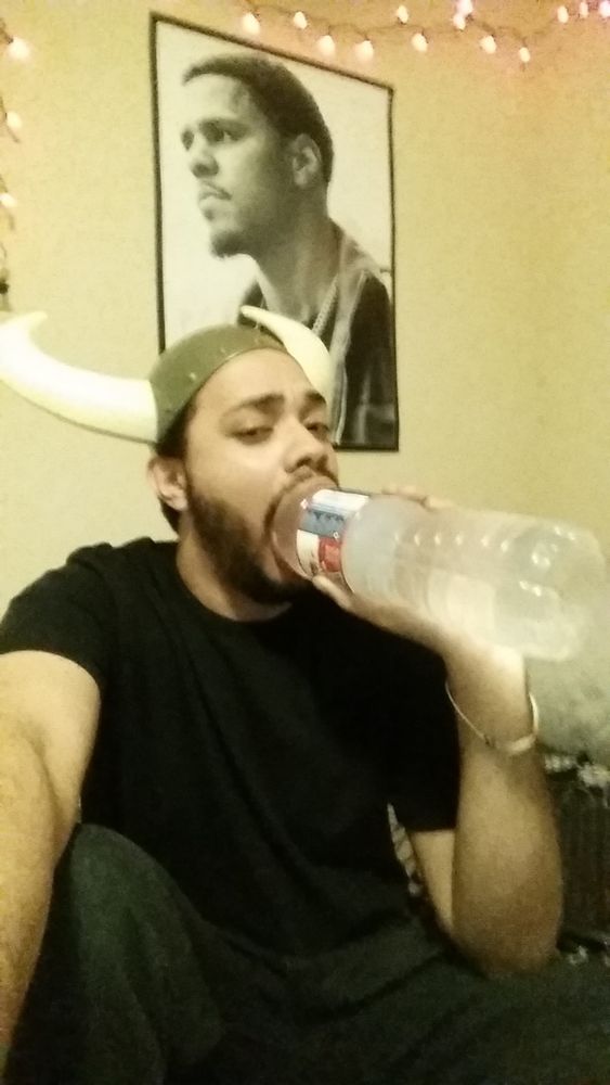 Guy staying hydrated while wearing a viking helmet