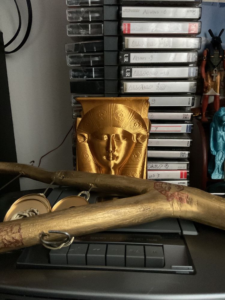The sistrum sitting before my bust if Hathor, atop my boombox and in front of my cassette collection.