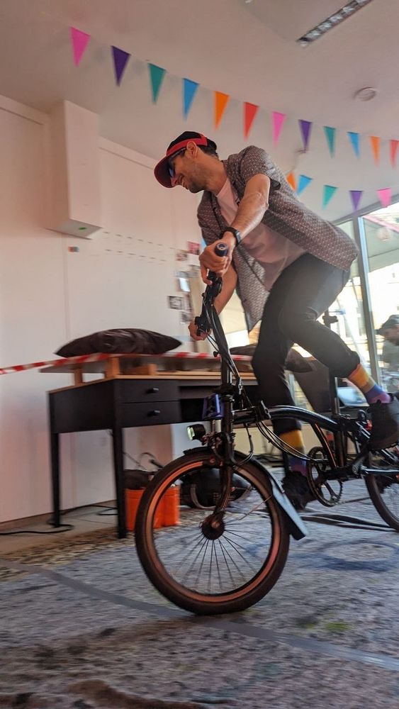Radfahrer mit Flatterhemd auf Brompton fährt um enge Kurve