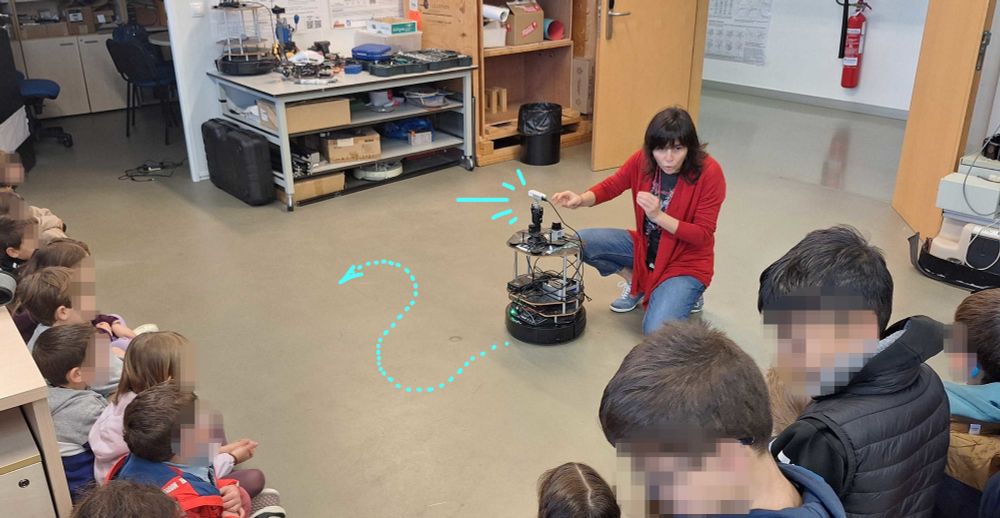 Researcher Ana Cristina Murillo telling a group of kids how our Turtlebots use laser to "see" where they can go to without crashing.