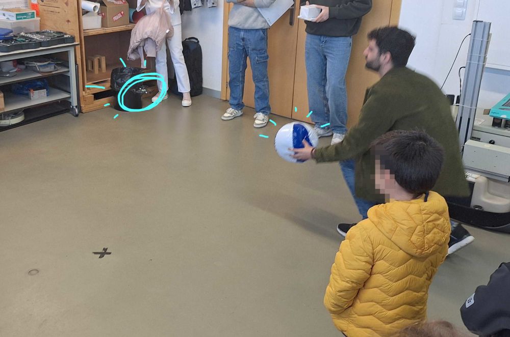 PhD student David Morilla showing kids how a drone can follow a beach ball.